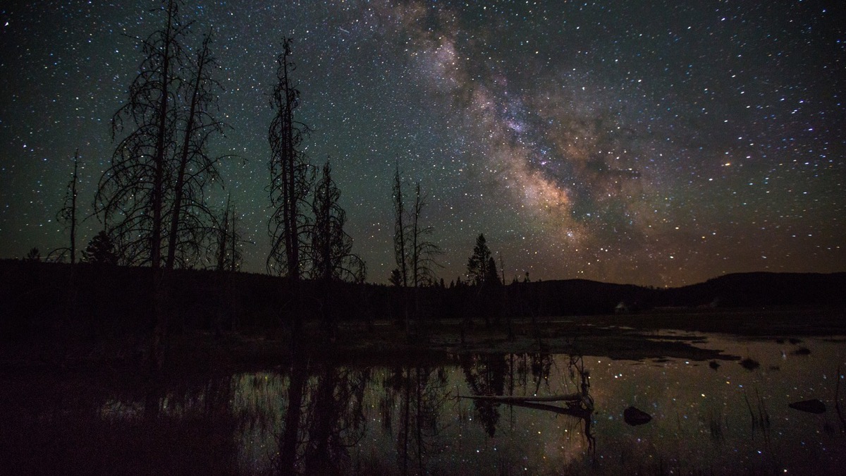 The Milky Way and stars reflected on a backcountry lake in Yellowstone National Park